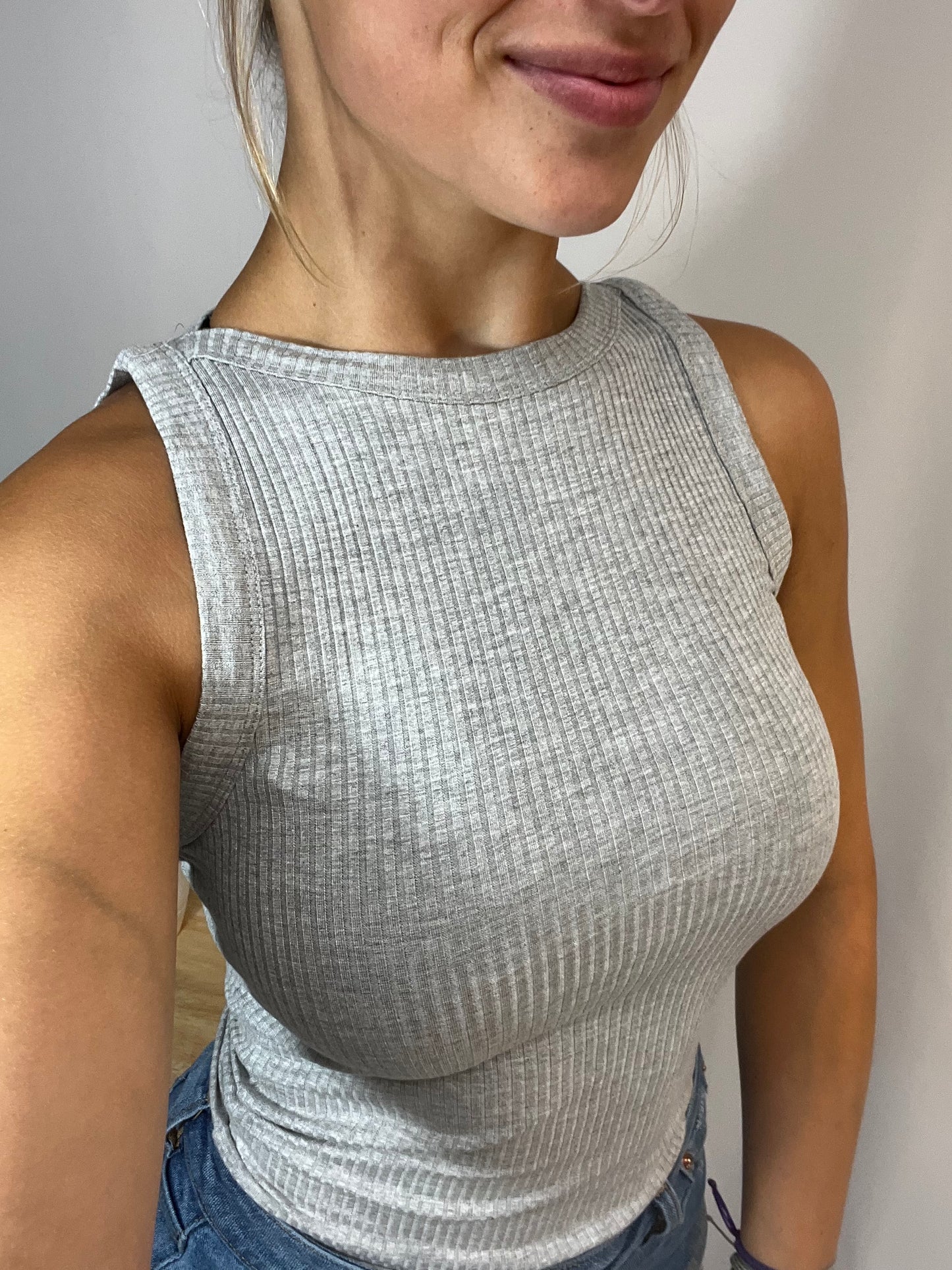 Close-up of soft ribbed fabric tank top with high neckline in grey color