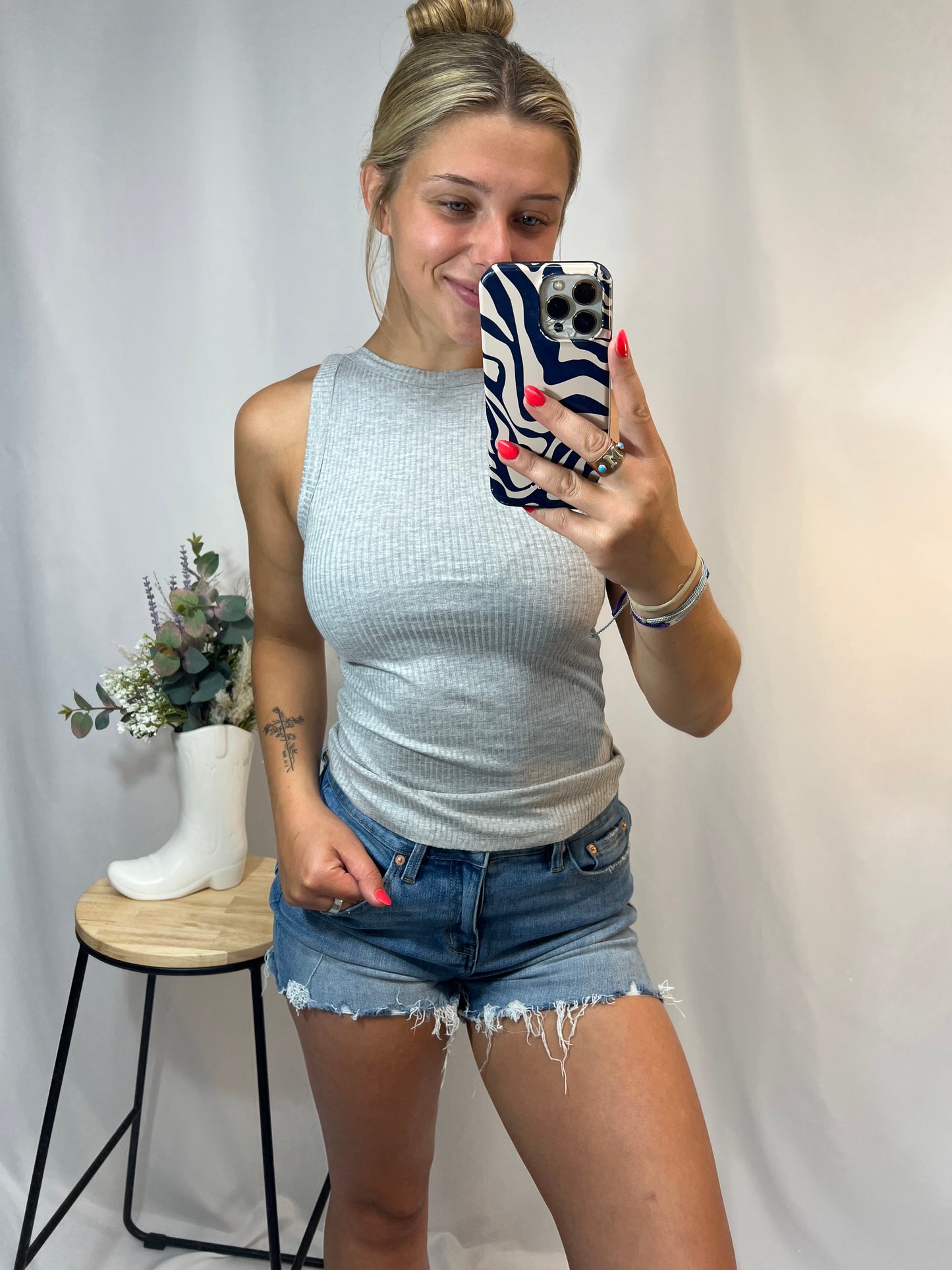 Heather grey ribbed high neckline tank top styled with cut-off jean shorts