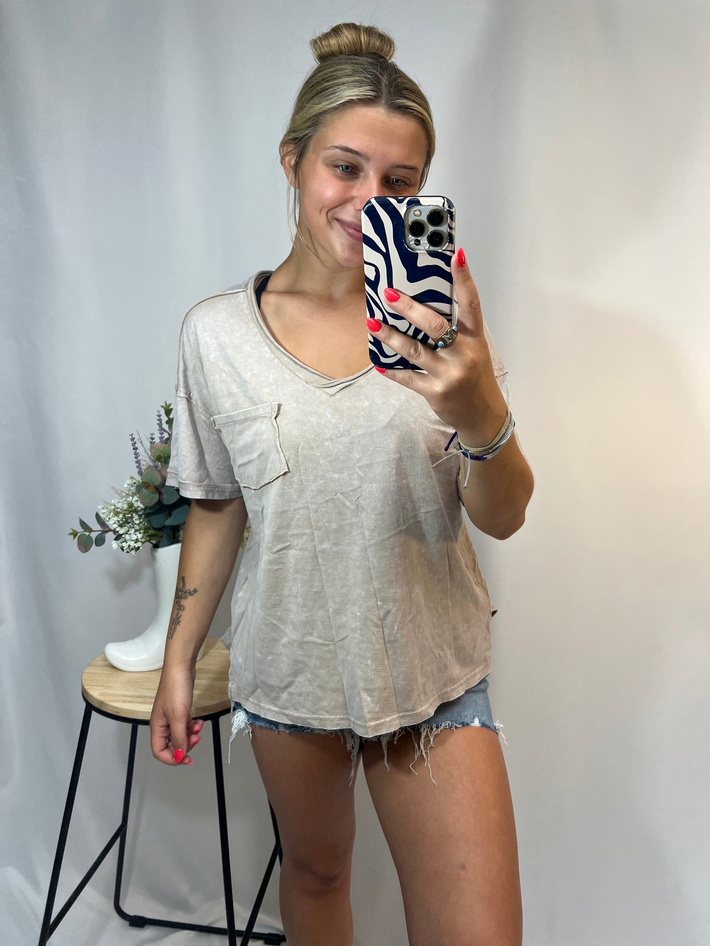 Casual boxy fit taupe v-neck t-shirt styled with high-rise distressed shorts