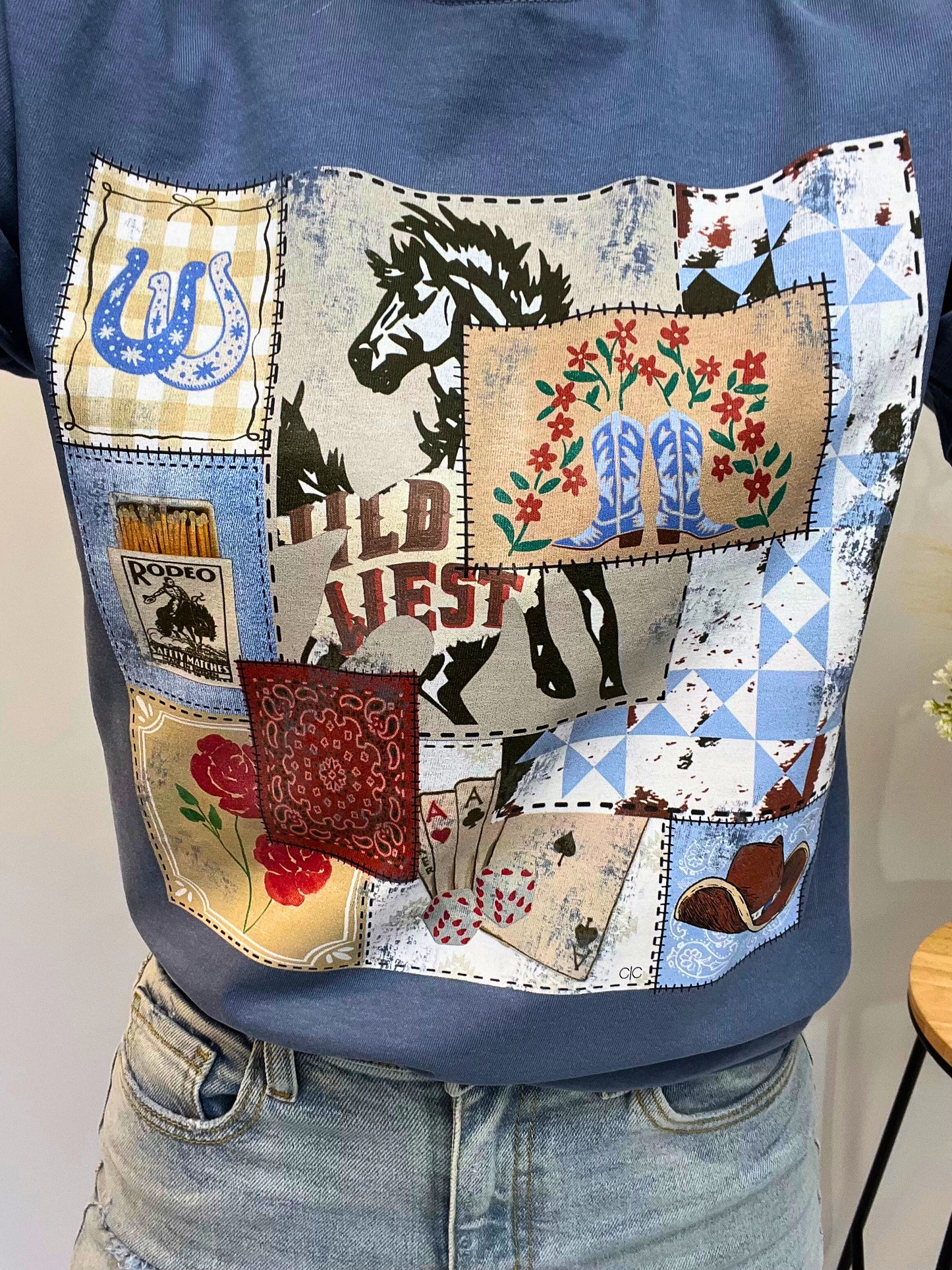 Close-up of Rodeo Patch Tee’s vintage rodeo stamps graphic print on soft cotton — western tee for girls with cute cowgirl style.