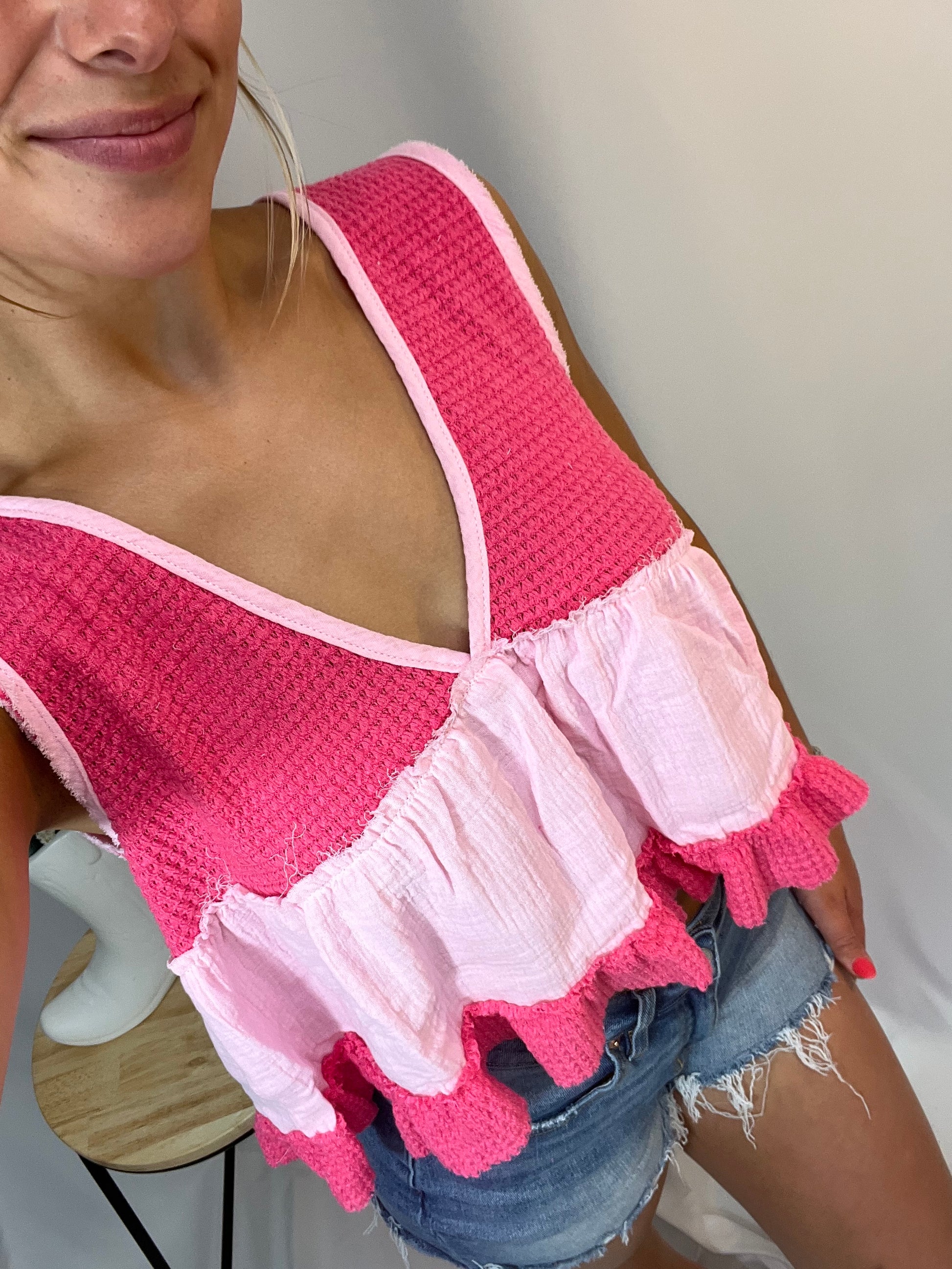 Close-up of bright pink and baby pink ruffle babydoll tank with textured detail