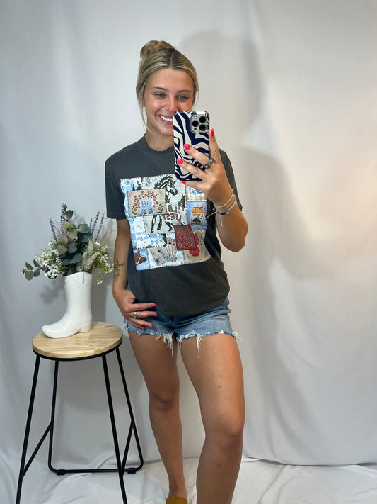 Photo of blonde woman wearing Rodeo Patch Tee in Graphite with distressed denim shorts, smiling in mirror selfie — western cowgirl aesthetic.