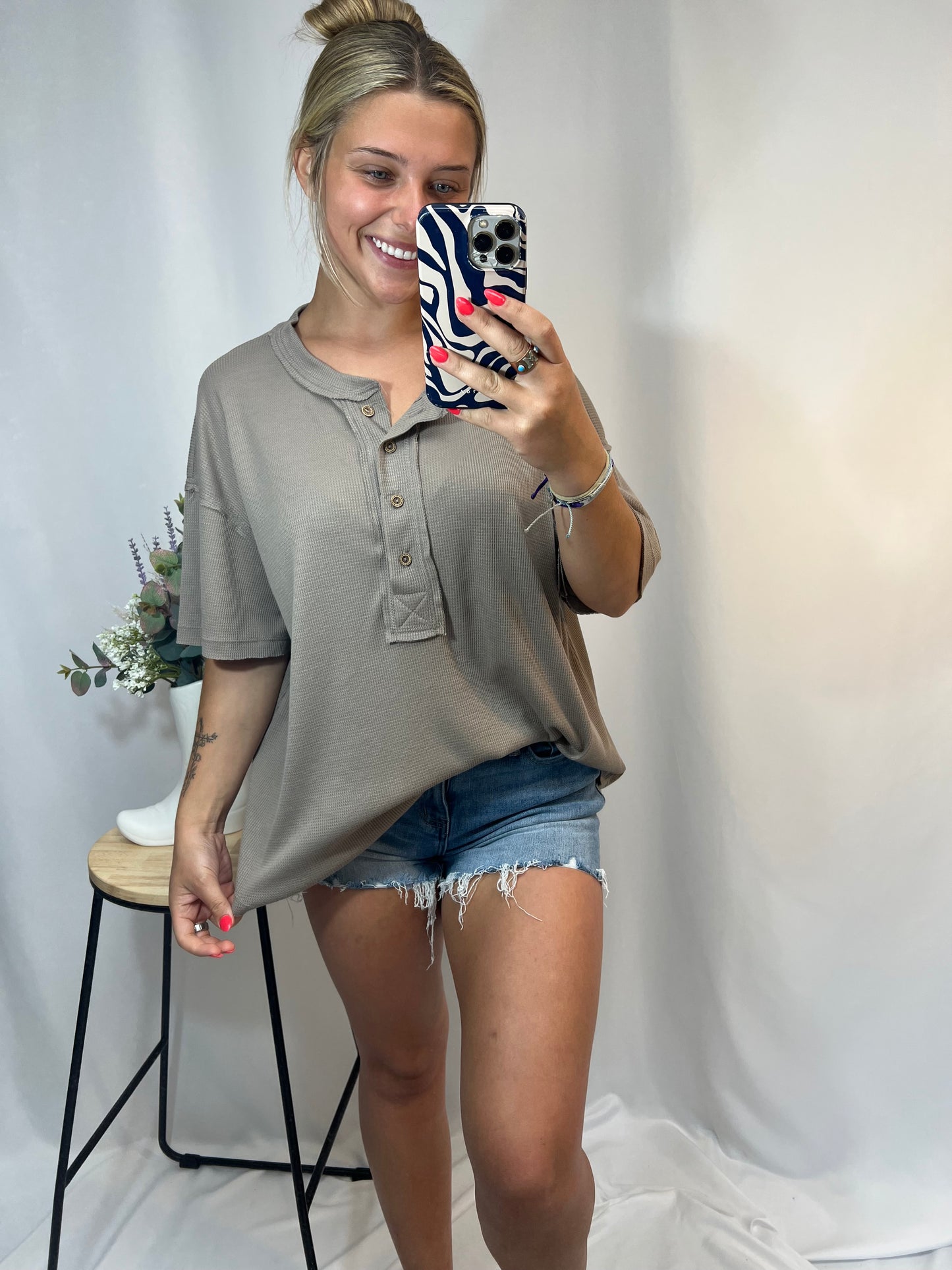 Blonde girl in taupe oversized waffle knit Henley tee with high-rise denim shorts — cute casual outfit for girls