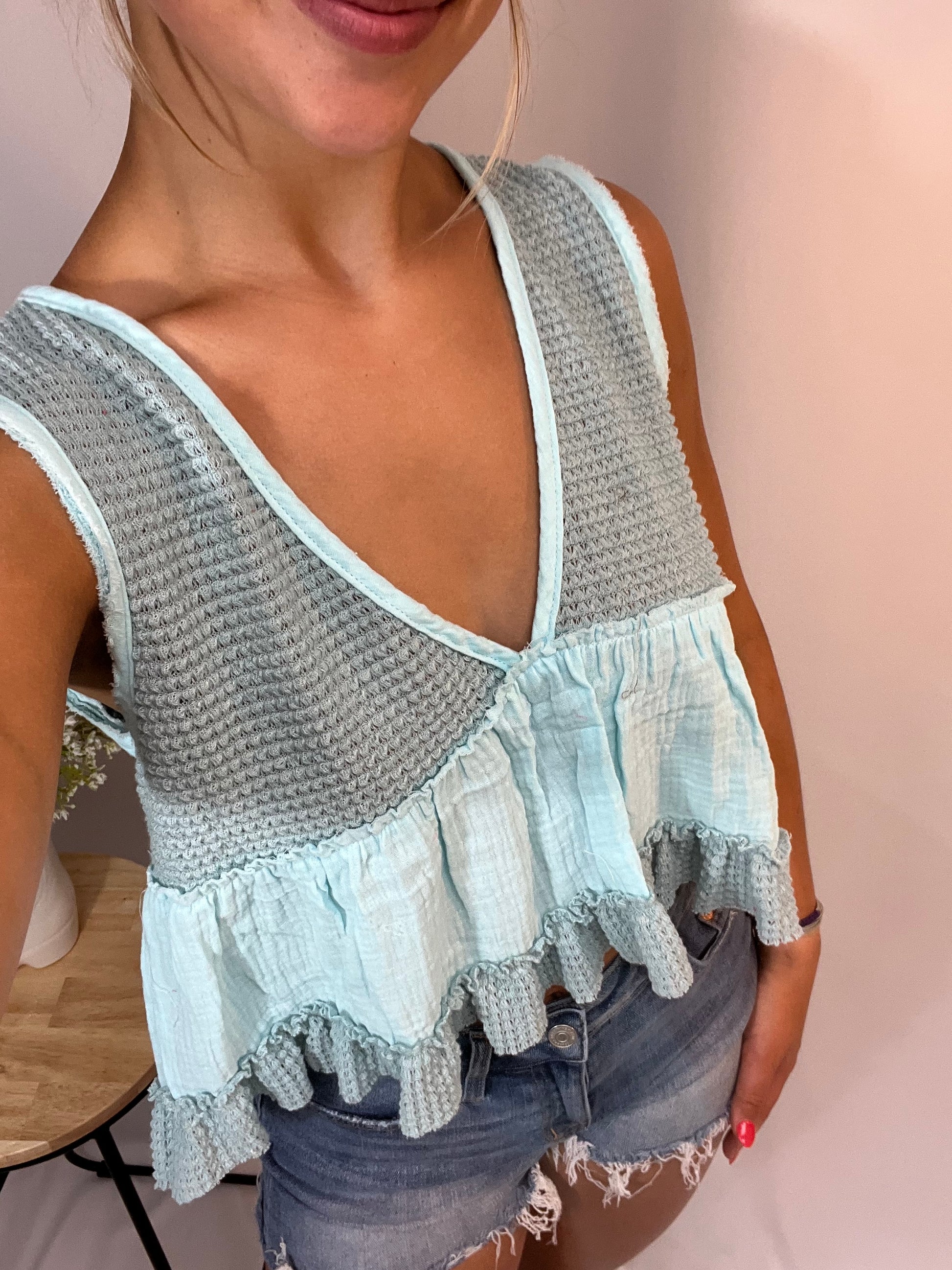 Close-up of mint babydoll tank with textured knit top and gauze ruffle hem