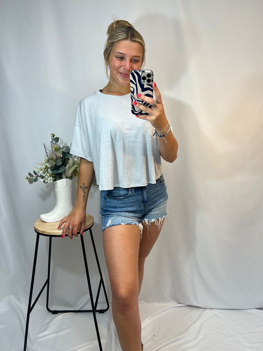 Young woman wearing heather grey oversized tee with distressed denim shorts