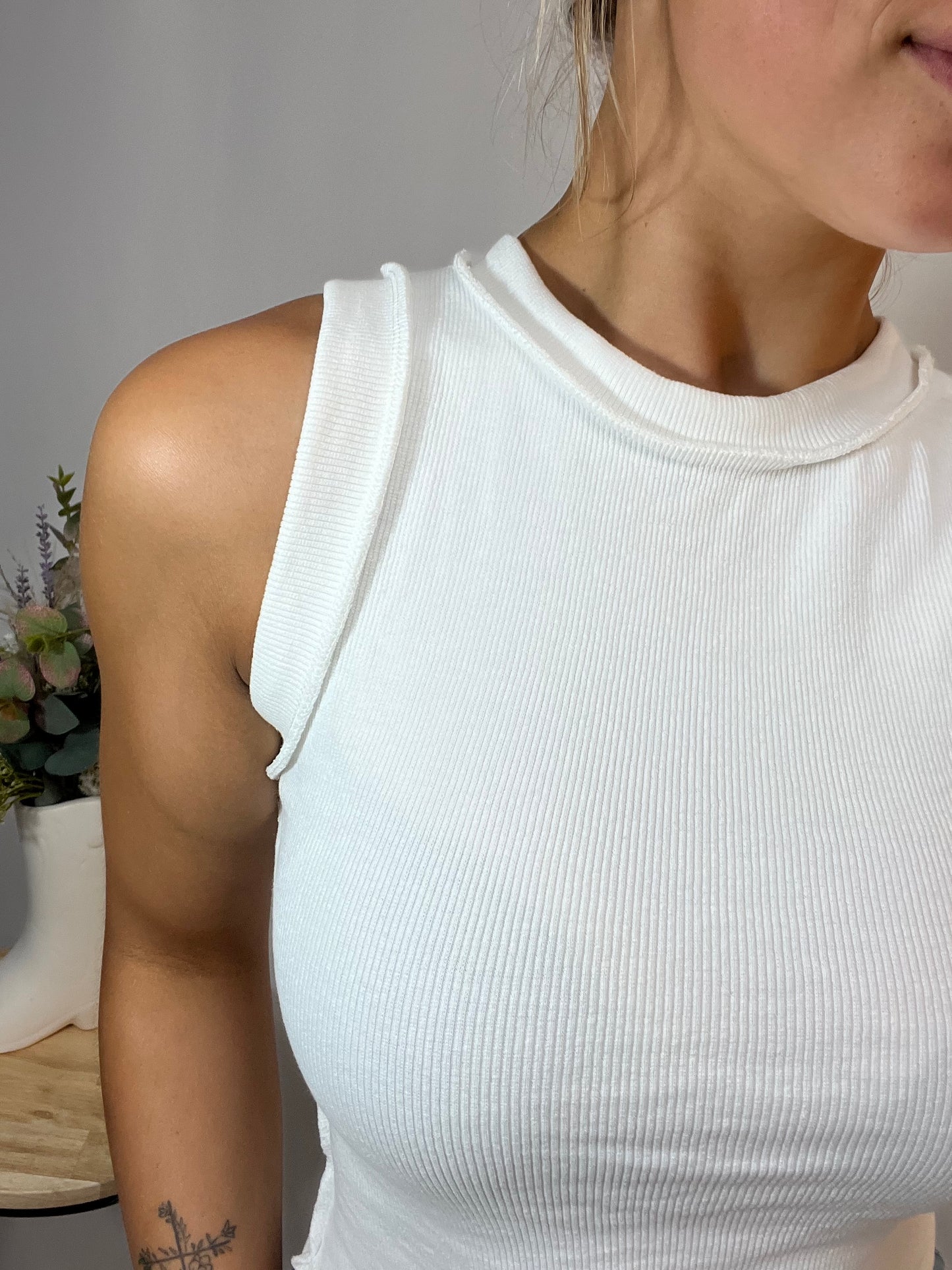 Close-up of the white ribbed cotton tank for women, showing high neckline and flattering fit.