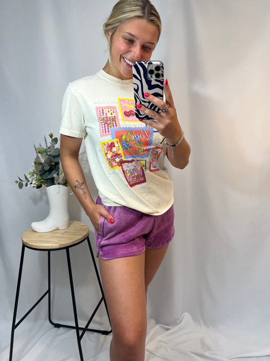 Woman wearing plum mineral wash dolphin shorts and graphic t-shirt