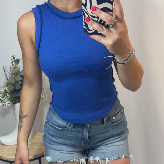 Fit clip showing girl in royal blue ribbed cotton tank top styled with shorts, showing stretch and sporty fit for summer fashion.