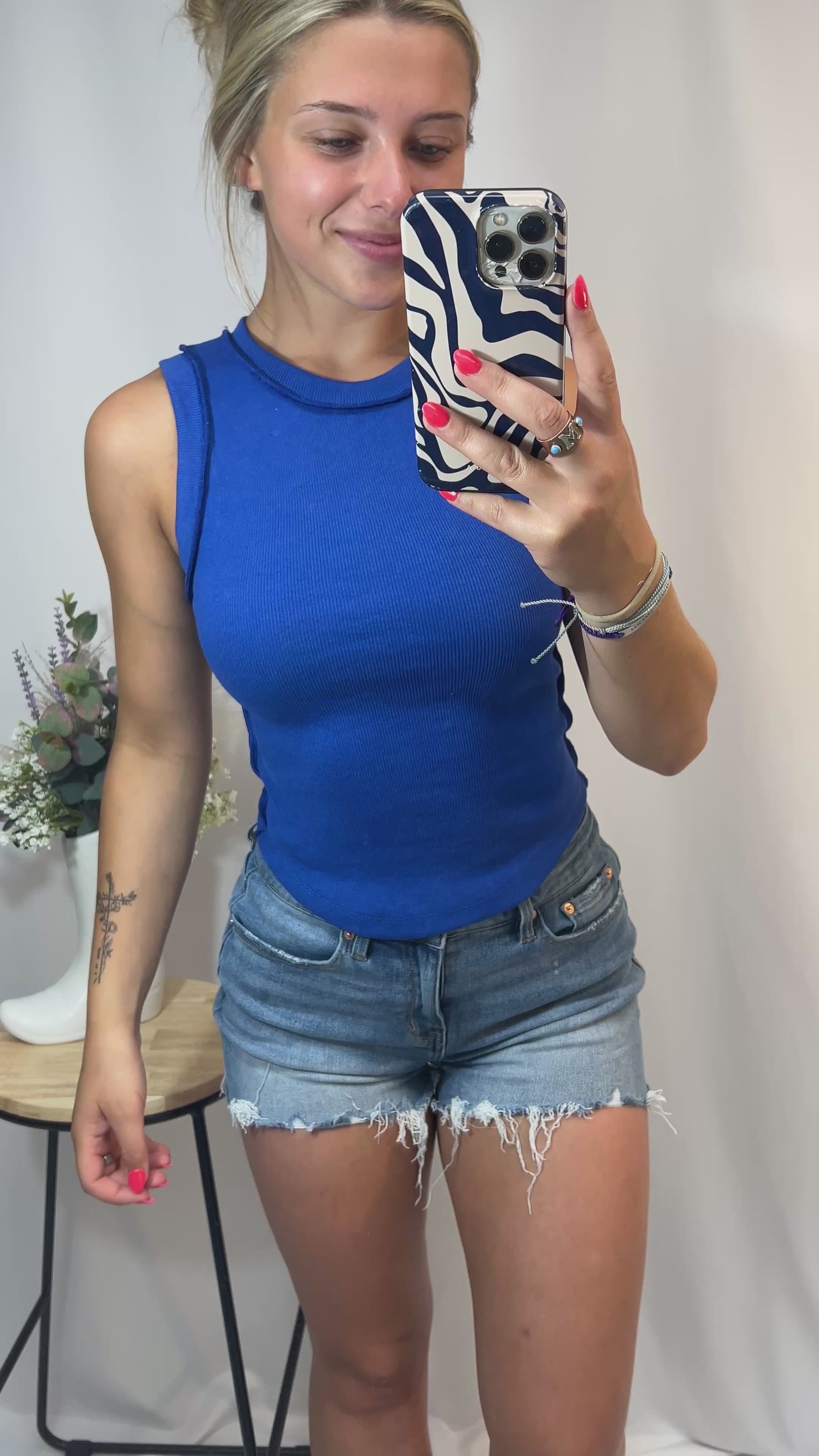 Fit clip showing girl in royal blue ribbed cotton tank top styled with shorts, showing stretch and sporty fit for summer fashion.