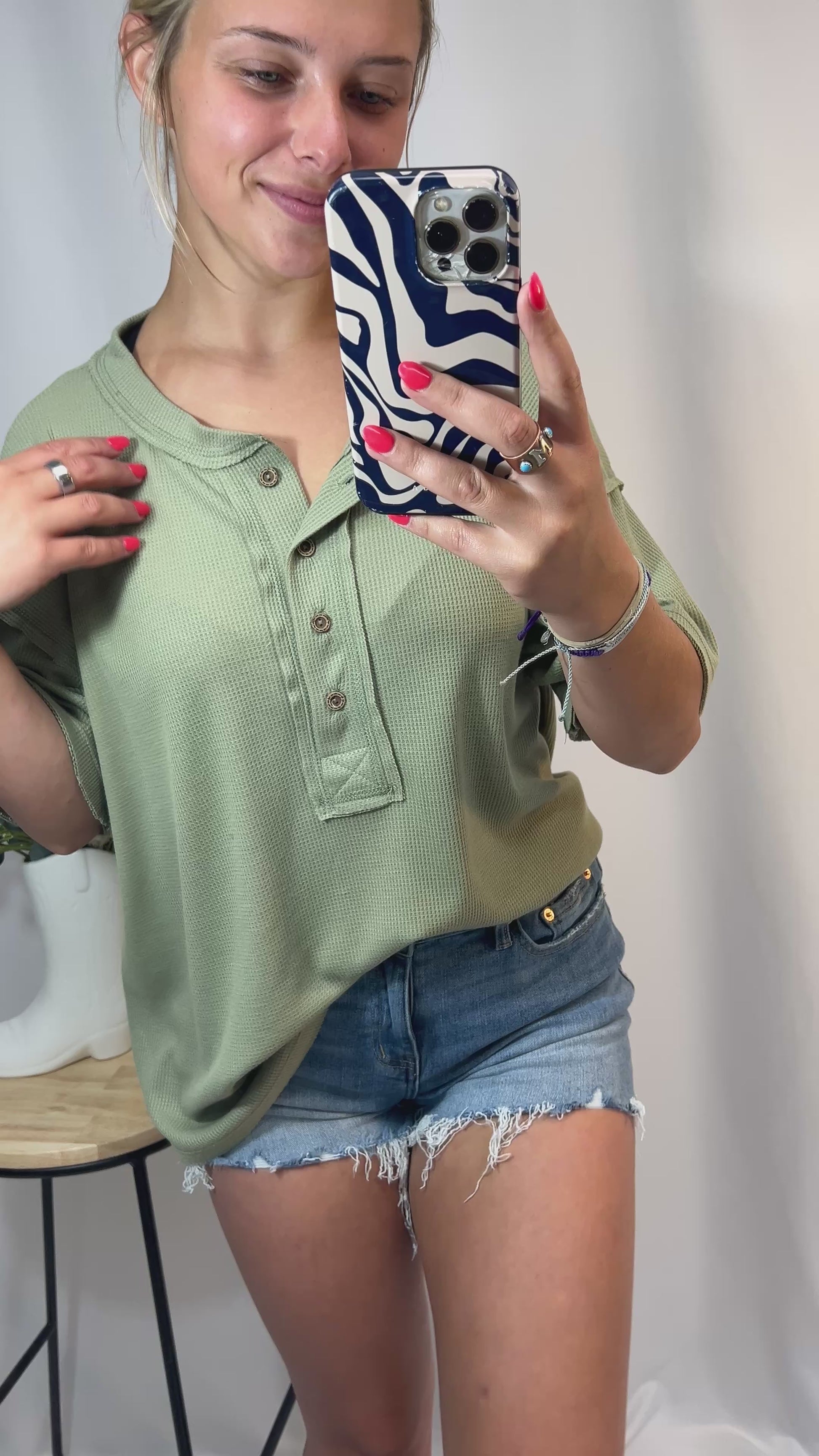 Model styling sage green oversized Henley shirt for girls — soft waffle knit casual tee with raw edge details