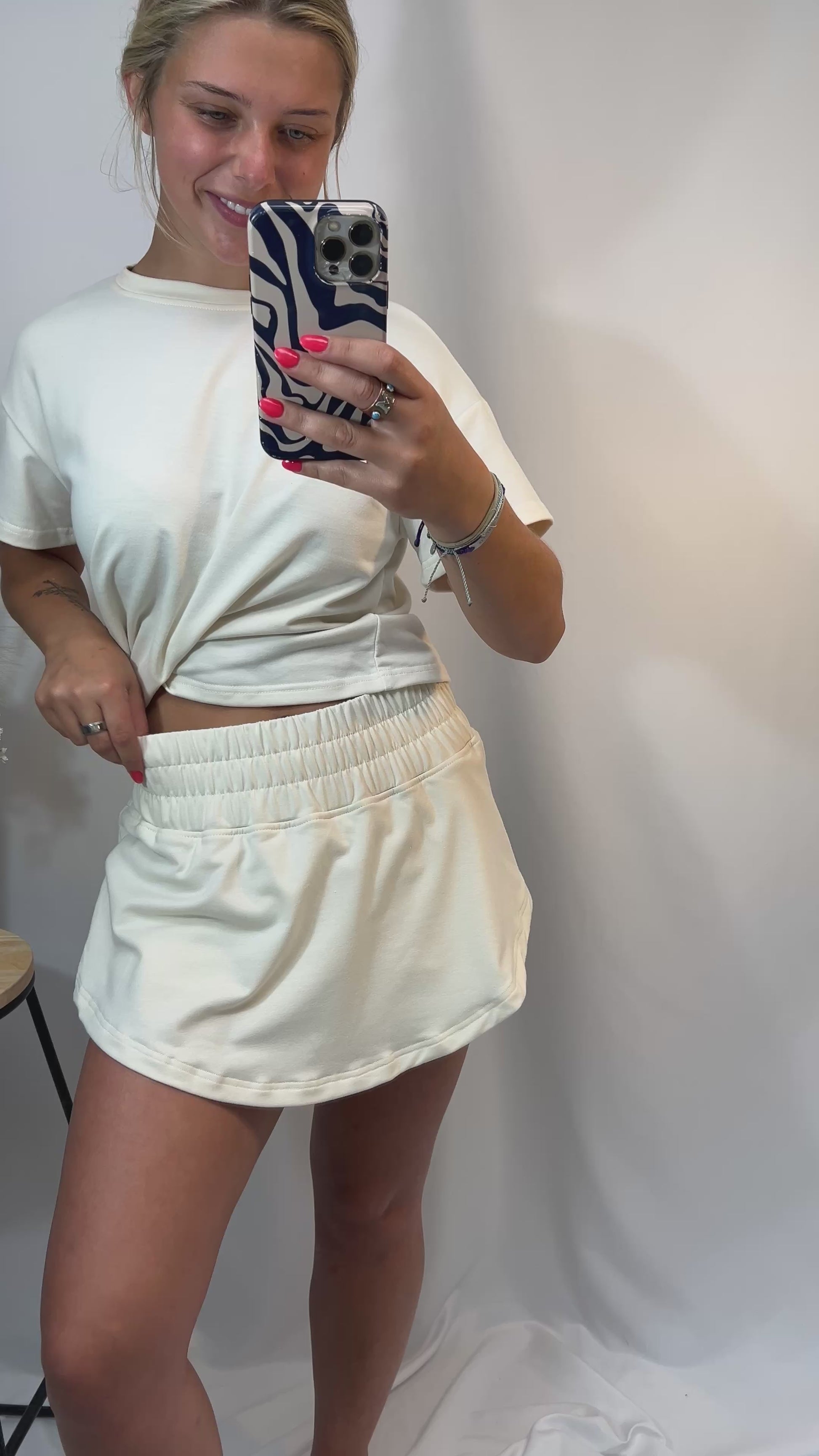 Woman wearing ivory cropped tee and matching high-waist skort with elastic waistband