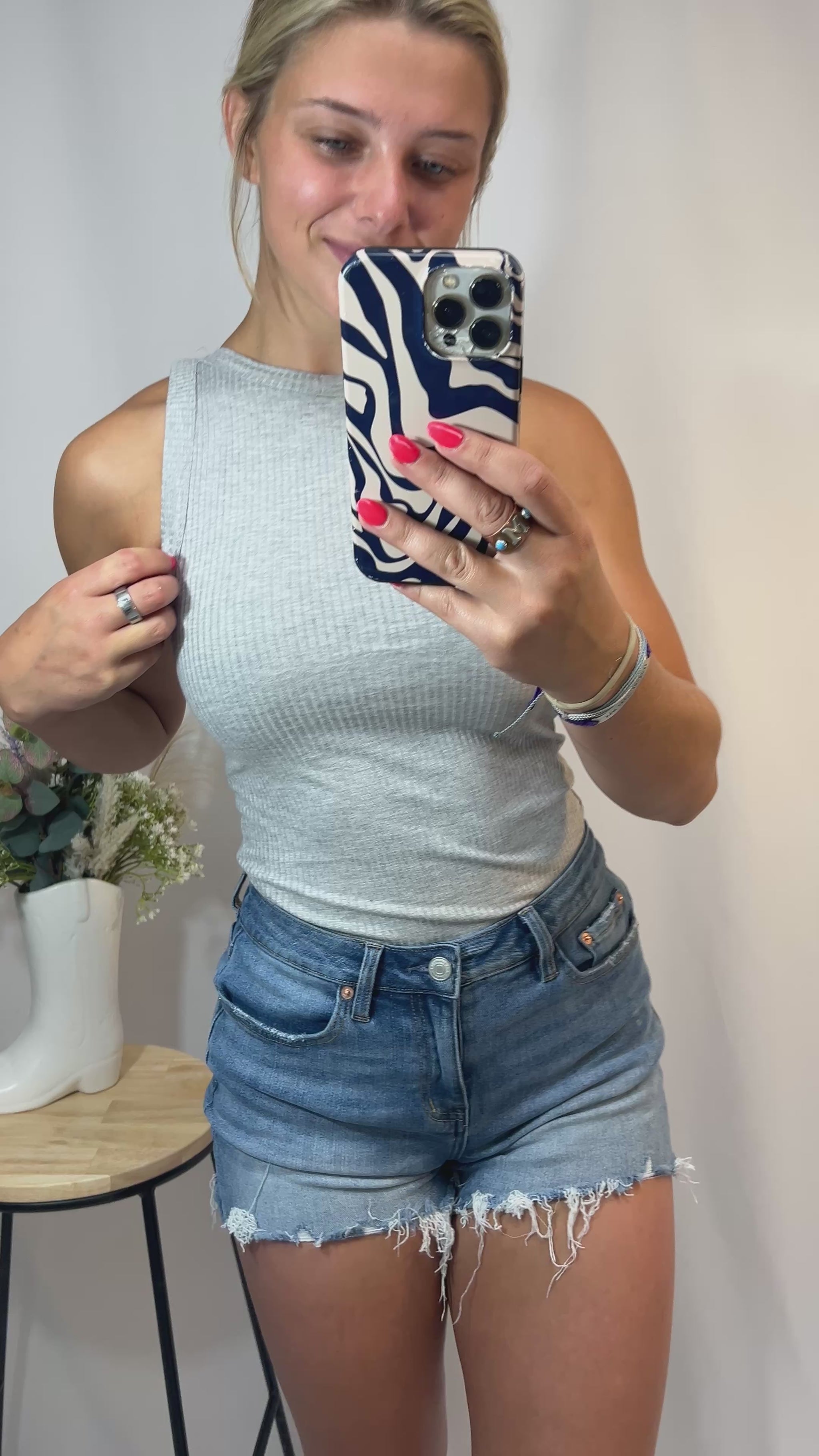 Close-up of soft ribbed fabric tank top with high neckline in grey color
