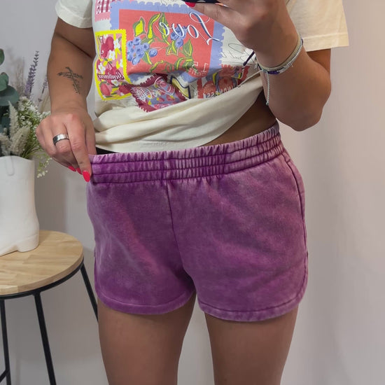 Plum mineral-washed dolphin hem shorts styled with cream printed tee