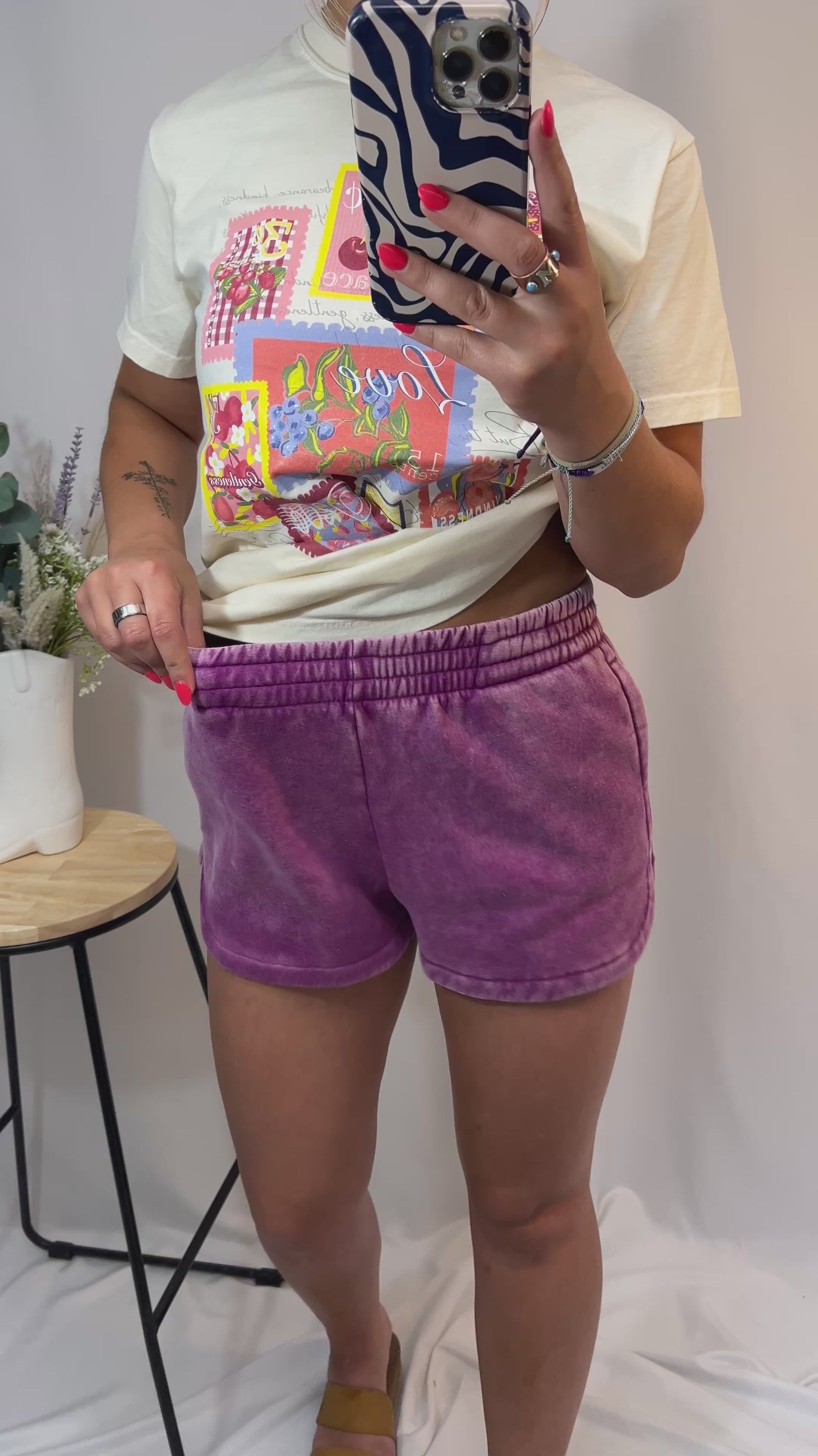 Plum mineral-washed dolphin hem shorts styled with cream printed tee
