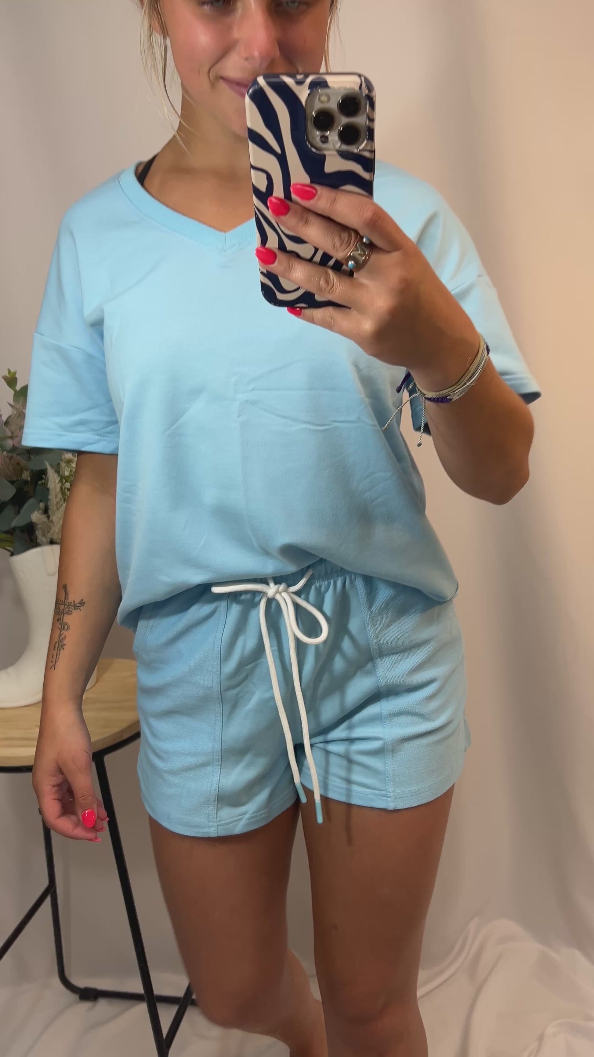 Close-up of blue two-piece lounge set with patchwork drawstring shorts and casual v-neck top